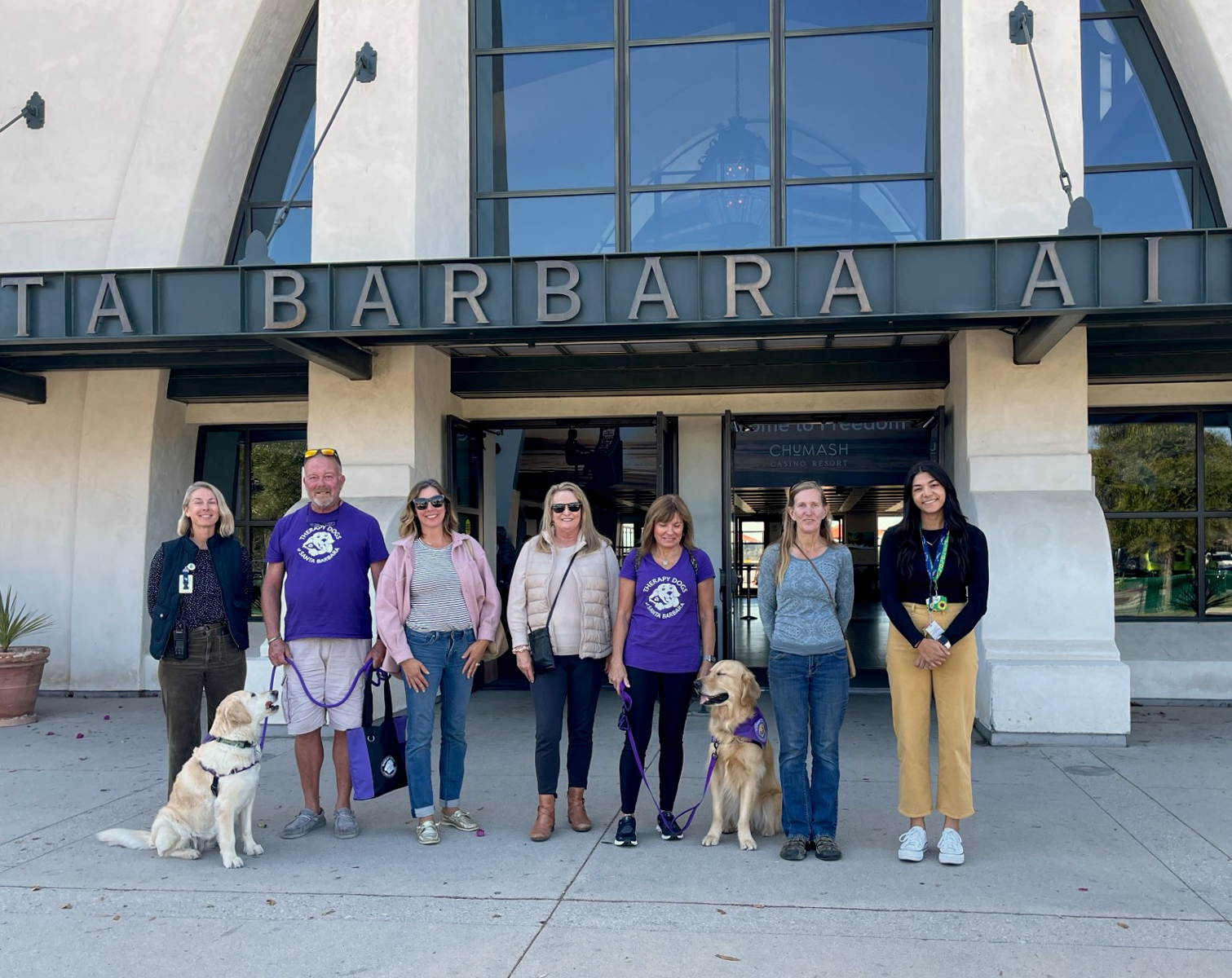 Therapy dogs and their volunteers stand in front of the SBA Terminal