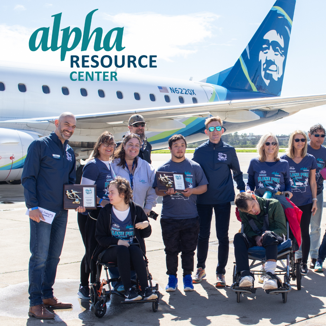 Members of alpha resource pose in front of an airplane.