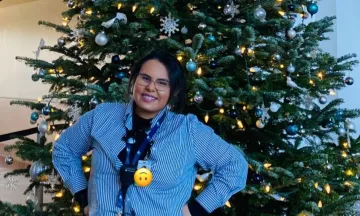 SBA Staff Nora in front of Christmas Tree