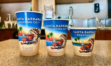 Three sizes of coffee cups with the SB Roasting Co design are lined up next to each other