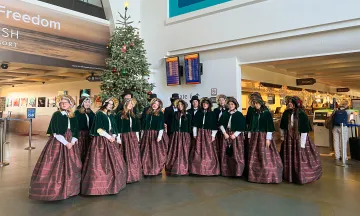 Carolers perform inside the terminal.