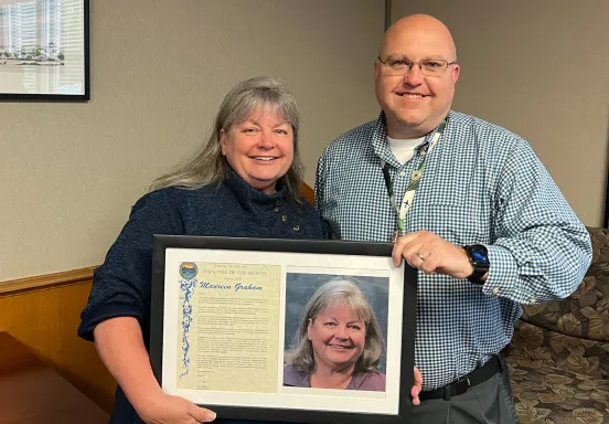 Mo Graham poses with Airport Director Chris Hastert holding a plaque