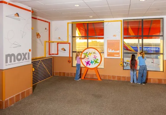 Three kids interact with the MOXI exhibit at SBA