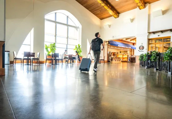 Man walking through terminal with luggage