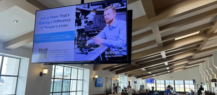 A large digital display ad inside the terminal gate area