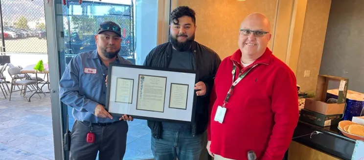 Two members of the custodial team pose with their plaque. 