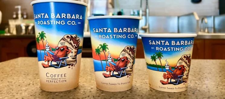 Three sizes of coffee cups with the SB Roasting Co design are lined up next to each other