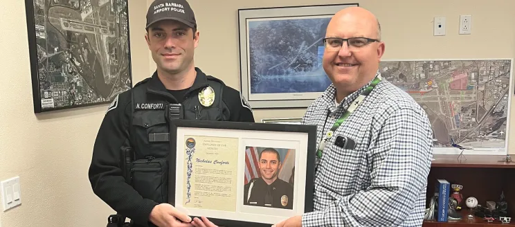 Patrol Officer Nick Conforti poses with Airport Director Chris Hastert