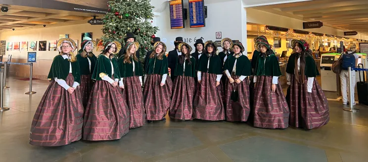 Carolers perform inside the terminal.