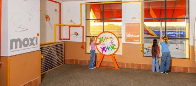 Three kids interact with the MOXI exhibit at SBA