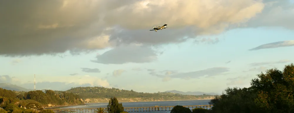 Small airplane flying over Goleta Pier 