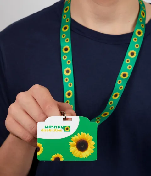 Person wearing a sunflower lanyard with an attached card that reads "hidden disabilities"